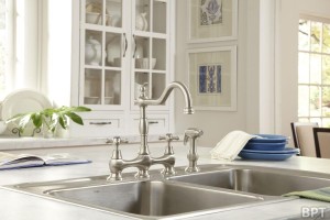 A traditional style faucet (Opulence Collection by Danze) in Stainless Steel adds a bit of craftsmanship to this contemporary white kitchen.
